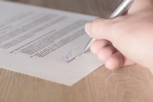 Hand, die einen Vertrag unterschreibt
