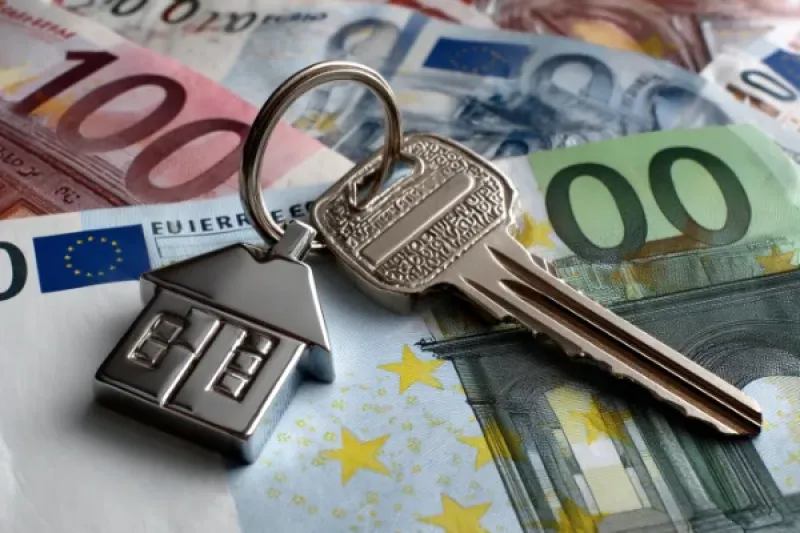 Schlüssel mit Schlüsselanhänger auf einem Geldstapel