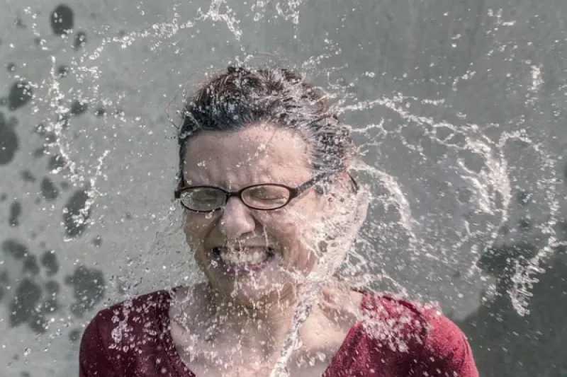 Frau mit Wasser übergossen